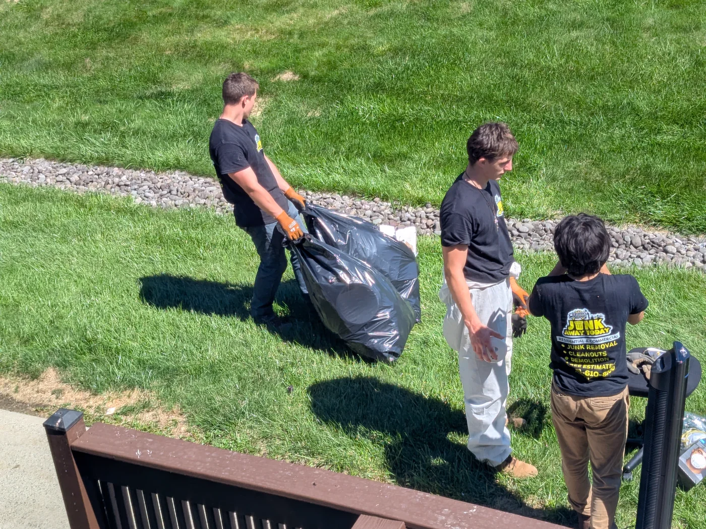 Junk Away Today crew carrying a large bag during a residential cleanup