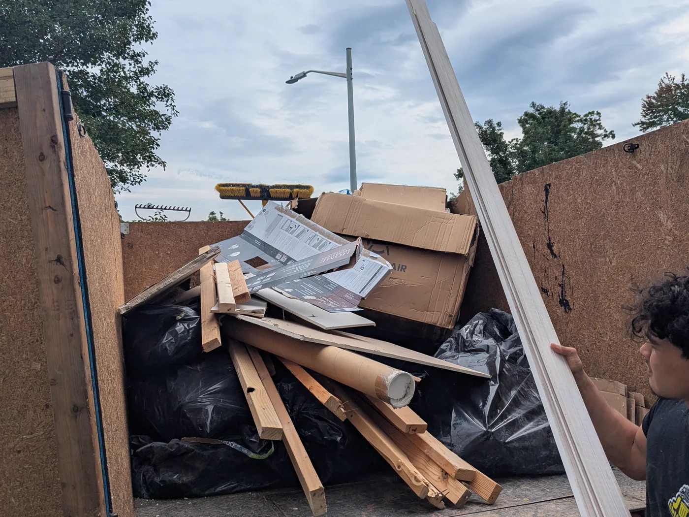 Junk Away Today crew member loading mixed debris into the truck