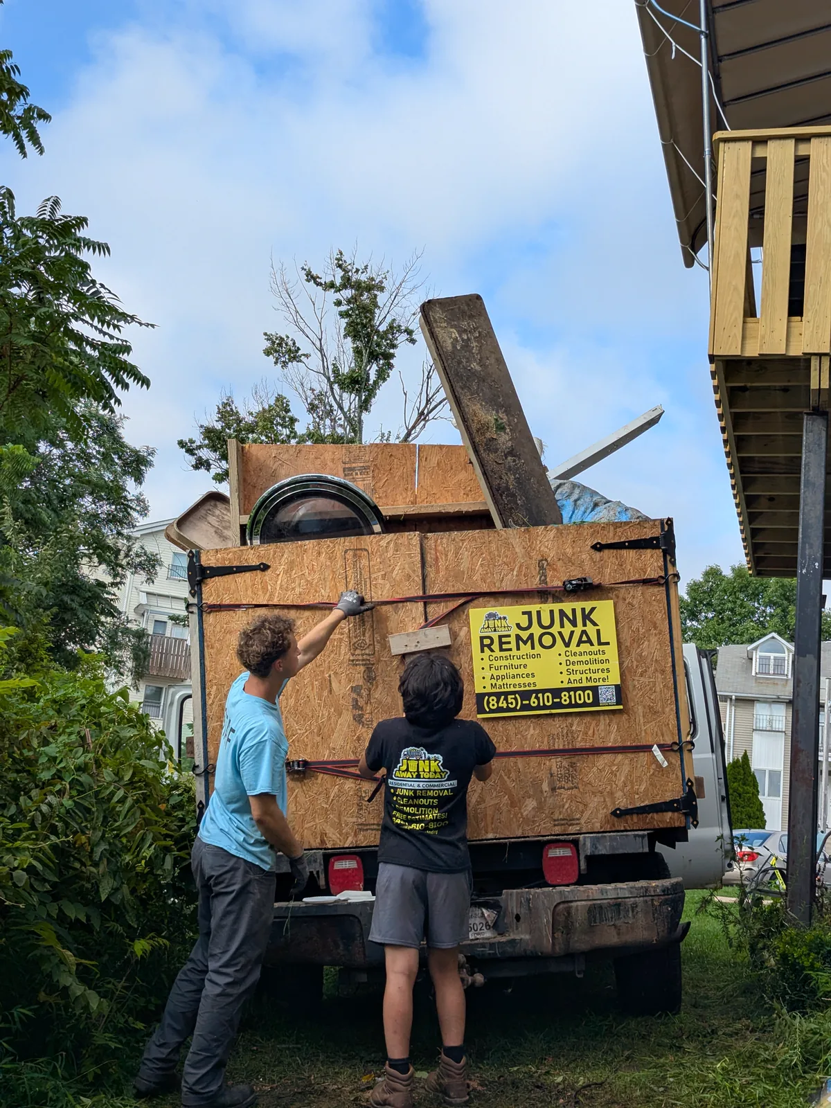 Junk Away Today crew securing shed debris in the truck